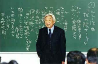 小川和佑先生黒板を背に講義・板書の文字は原稿の筆跡そのまま